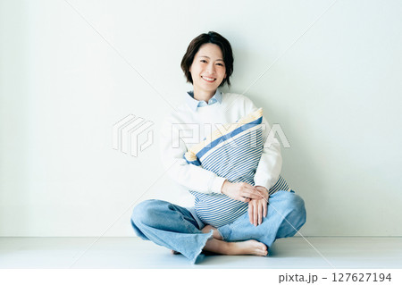 壁の前に座る若い女性 127627194