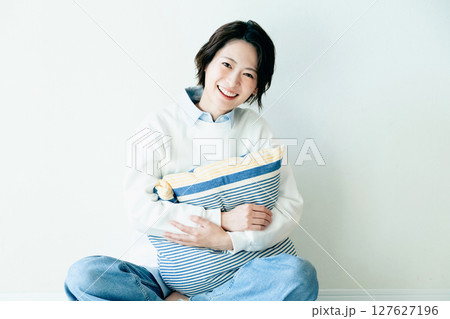 壁の前に座る若い女性 壁の前に座る若い女性 127627196
