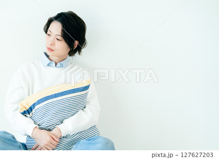 壁の前に座る若い女性 壁の前に座る若い女性 127627203