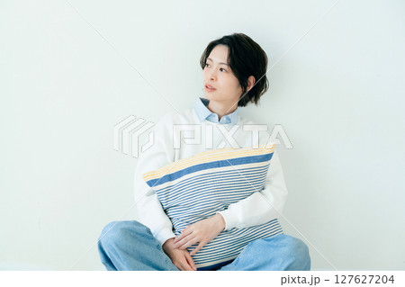 壁の前に座る若い女性 127627204