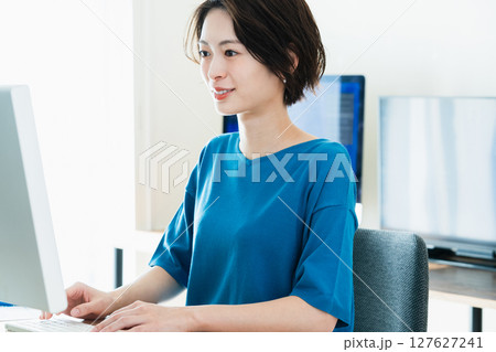 パソコンに向かうビジネスウーマン パソコンに向かうビジネスウーマン 127627241
