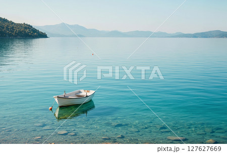 波のない静かな青い湖面と、孤独に浮かぶ一艘の舟 波のない静かな青い湖面と、孤独に浮かぶ一艘の舟 127627669