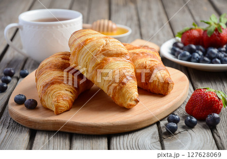 Fresh Croissants with fresh berries on rustic wooden background, selective focus Fresh Croissants with fresh berries on rustic wooden background, selective focus 127628069