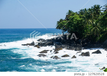 The Charm of Rocky Beaches with Clear Blue Waves and Tropical Vegetation in Sumatra, Lampung 127628528