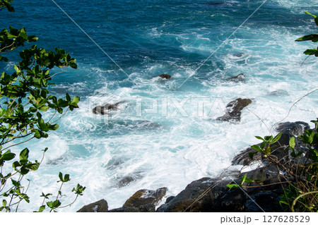 Blue Waves Breaking on the Coral Reef on the Tropical Coast of Sumatra, Lampung 127628529