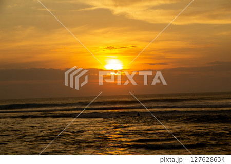 Golden Sunset Silhouette Over Sea with Waves and Cloudy Sky, Sumatra Beach, Lampung 127628634