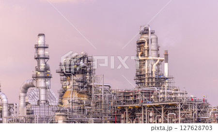 Oil refinery petrochemical plant at dusk illuminated storage tank industrial infrastructure, Oil refinery petrochemical product storage tank at oil refinery factory industry, Global energy refinery. 127628703
