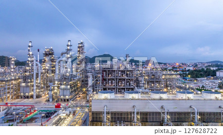 Oil refinery petrochemical plant at dusk illuminated storage tank industrial infrastructure, Oil refinery petrochemical product storage tank at oil refinery factory industry, Global energy refinery. Oil refinery petrochemical plant at dusk illuminated storage tank industrial infrastructure, Oil refinery petrochemical product storage tank at oil refinery factory industry, Global energy refinery. 127628722