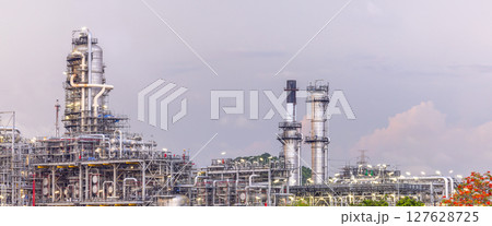 Oil refinery petrochemical plant at dusk illuminated storage tank industrial infrastructure, Oil refinery petrochemical product storage tank at oil refinery factory industry, Global energy refinery. 127628725