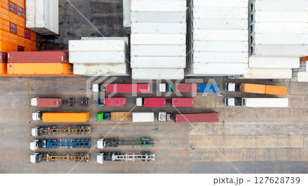 Aerial view semi trailer trucks stand on the parking lot and wait for loading and unloading cargo container at container terminal port, Global business logistic transportation semi trailer trucks. 127628739