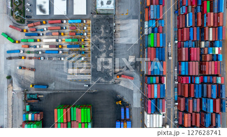 Aerial view semi trailer trucks stand on the parking lot and wait for loading and unloading cargo container at container terminal port, Global business logistic transportation semi trailer trucks. Aerial view semi trailer trucks stand on the parking lot and wait for loading and unloading cargo container at container terminal port, Global business logistic transportation semi trailer trucks. 127628741