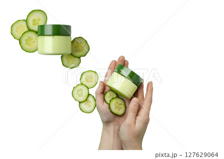 Hands hold skin cream and cucumber slices, isolated on white, PNG 127629064