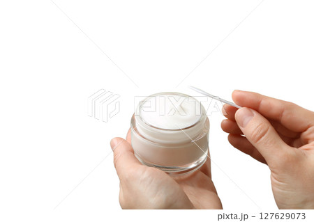 Preparing to apply a rich moisturizing cream, isolated on white, PNG 127629073