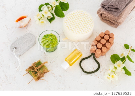 Towels with body care products and branches of jasmine on the white background. Towels with body care products and branches of jasmine on the white background. 127629523