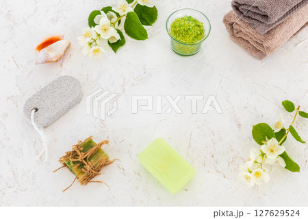 Towels with body care products and branches of jasmine on the white background. Towels with body care products and branches of jasmine on the white background. 127629524