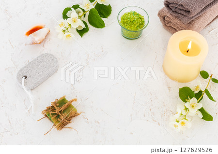 Towels with body care products and branches of jasmine on the white background. 127629526