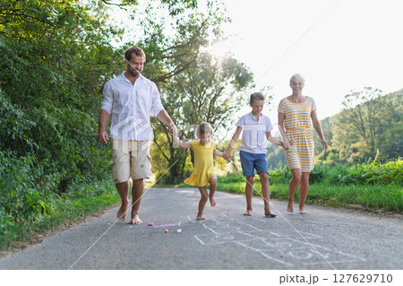 A family with small children running barefoot on a road in summer. A family with small children running barefoot on a road in summer. 127629710