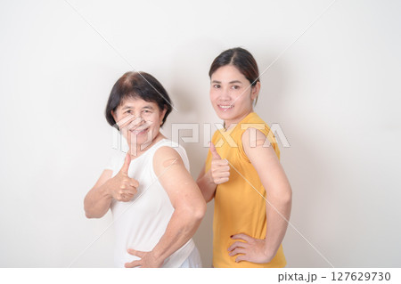 Adult and Elderly Woman with bandage after received vaccine. Vaccination and Immunization for Influenza, HPV, Zoster, IPD, DTP, Dengue, Encephalitis, Rabies, Pneumococcal Hepatitis B and Covid vaccine 127629730