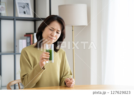 自宅で青汁を飲むミドルの女性 自宅で青汁を飲むミドルの女性 127629823