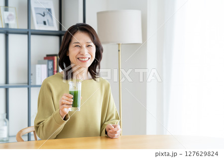 自宅で青汁を飲むミドルの女性 自宅で青汁を飲むミドルの女性 127629824