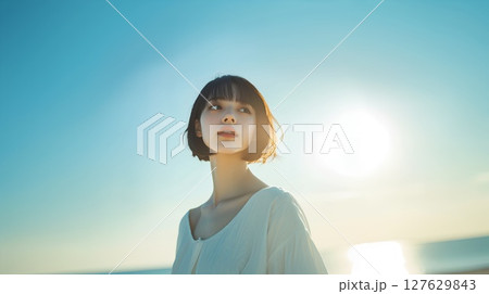 夕焼けの空を見上げる女性 127629843