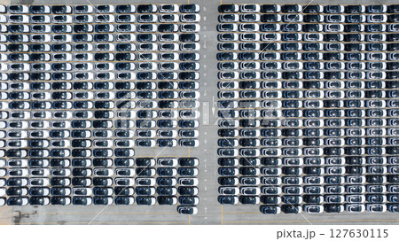 Aerial view of new ev cars stock at RoRo roll on roll off terminal international port, New electric vehicle ev cars parking lot, Automotive industry sea freight transportation logistic business. 127630115