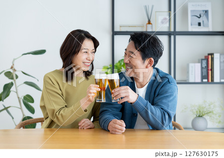 自宅でビールを飲むミドルの夫婦 自宅でビールを飲むミドルの夫婦 127630175