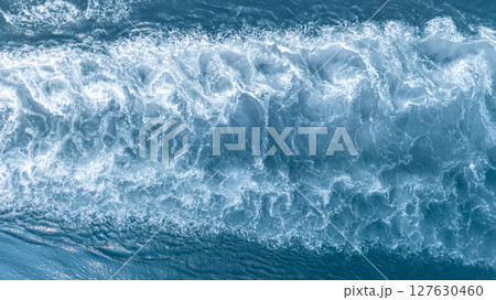 Aerial view ocean wave and white sea foam texture and background, Powerful sea current and turbulence abstract blue water pattern, Ocean wave white sea foam from ship. Aerial view ocean wave and white sea foam texture and background, Powerful sea current and turbulence abstract blue water pattern, Ocean wave white sea foam from ship. 127630460