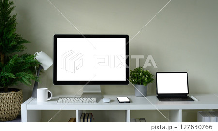 Modern workspace with desktop computer, digital tablet, and smartphone on a white desk Modern workspace with desktop computer, digital tablet, and smartphone on a white desk 127630766