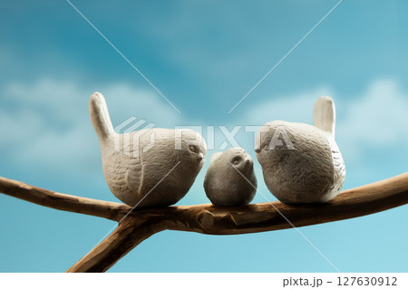 Mother, Father and baby birds perched on branch, symbolizing family love, care, and emotional bonding in nature Mother, Father and baby birds perched on branch, symbolizing family love, care, and emotional bonding in nature 127630912