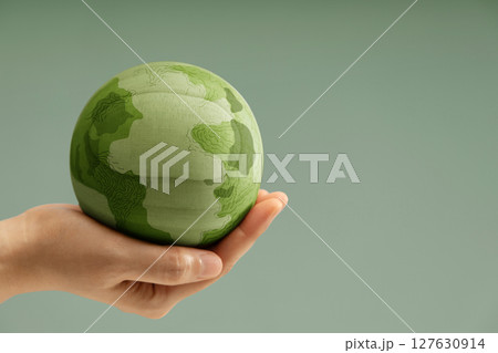 Green earth held gently in hands, symbolizing environmental conservation, care for the planet, and sustainability. Side view with copy space Green earth held gently in hands, symbolizing environmental conservation, care for the planet, and sustainability. Side view with copy space 127630914