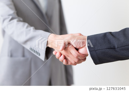 握手をするスーツ姿のビジネスマンとビジネスウーマン 127631045