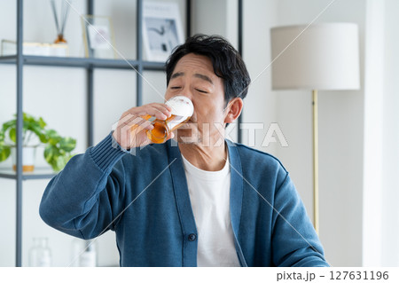 自宅でビールを飲むミドルの男性 127631196
