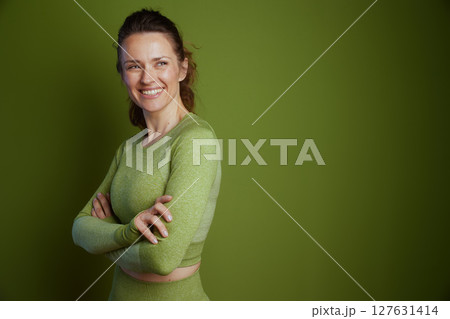 Self-assured woman in green athletic wear 127631414