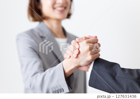 手を組むスーツ姿のビジネスマンとビジネスウーマン 127631436