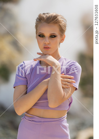 Portrait of beautiful fashion model posing on sunny summer day. She is set against natural backdrop of steam and gas in crater active volcano. She looking at camera, which could be seen as provocative Portrait of beautiful fashion model posing on sunny summer day. She is set against natural backdrop of steam and gas in crater active volcano. She looking at camera, which could be seen as provocative 127631608