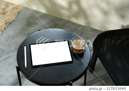 Digital tablet with blank screen, stylus, and coffee cup on modern black table Digital tablet with blank screen, stylus, and coffee cup on modern black table 127631640
