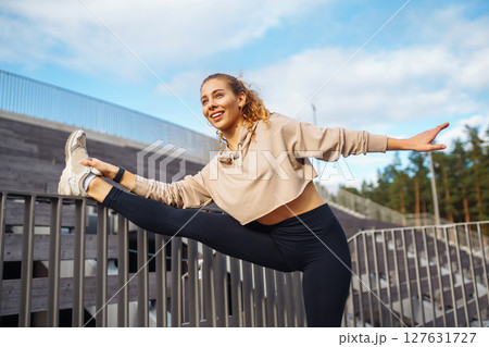 Athletic young woman training outdoors. Fitness woman stretching outdoors. Active lifestyle. Athletic young woman training outdoors. Fitness woman stretching outdoors. Active lifestyle. 127631727