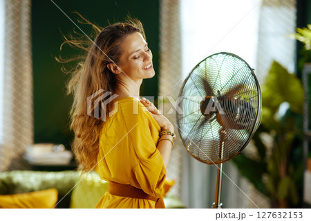 Serene Woman Enjoying Fan\'s Rotating Breeze 127632153