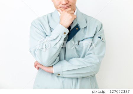 グリーンの作業服を着て悩むミドル男性ビジネスマン 127632387