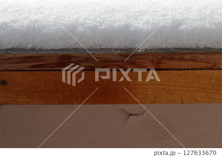 Fluffy snow lies on the wooden windowsill. Fluffy snow lies on the wooden windowsill. 127633670