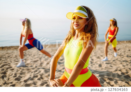 Young dancers in colorful swimsuits are dancing in morning. ?oncept of sports, fitness Active sport. Young dancers in colorful swimsuits are dancing in morning. ?oncept of sports, fitness Active sport. 127634163