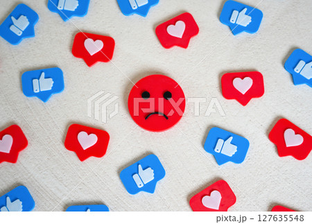 Sad face among social media likes. Burnout and doomscrolling. Chasing likes, social media addiction 127635548