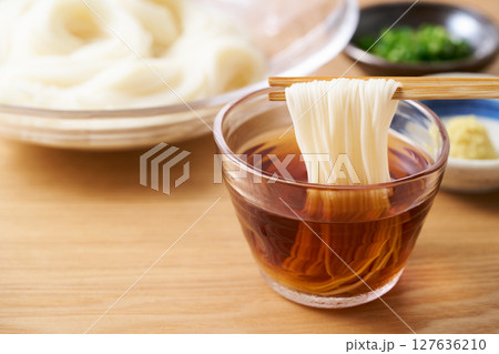 そうめんを麺つゆに漬ける 127636210