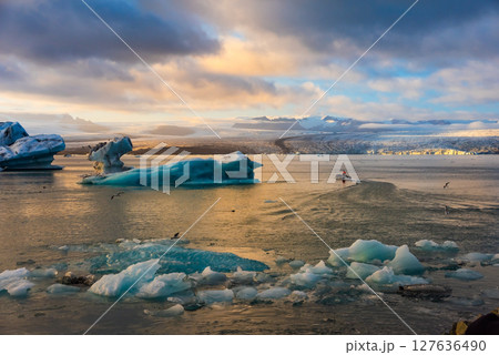 Ice Lagoon. Icebergs floating in Jokulsarlon glacier lagoon lake at sunset. South Iceland, Jokulsarlon Ice Waterfall. Great tourist attraction. 127636490