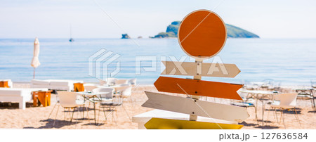 Banner wooden beach signpost with arrows on seaside promenade. Summer vacation, coastal leisure, and travel direction concept. 127636584
