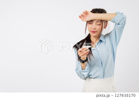 Sick asian woman fever, thermometer, forehead hand, temperature checking, looking sad as she tries to measure her temperature while feeling sick from illness and exhaustion, isolated white background 127638170