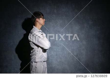 腕組みをする作業服姿の男性 腕組みをする作業服姿の男性 127638609