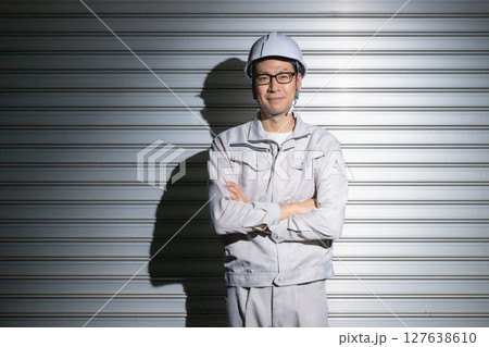 腕組みをする作業服姿の男性 腕組みをする作業服姿の男性 127638610