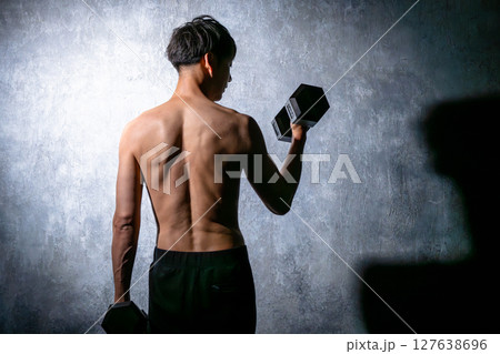 ダンベルで鍛える男性の後姿 127638696